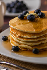 Close up shot of pancakes with butter and blue berries toppings