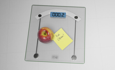 conceptual and modern still life delicious apple and yellow posit note text saying eat clean stuck on bathroom scale in weight loss dieting and healthy nutrition