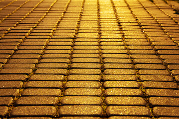Sunlight on paved cobblestone pavement