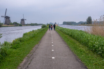 People walking in netherlands with windmills in the background