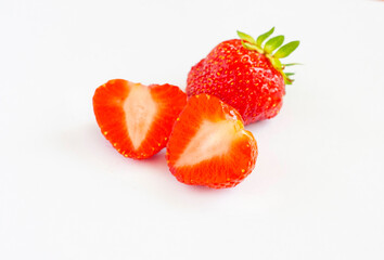 Whole and halves of strawberries isolated on a white background