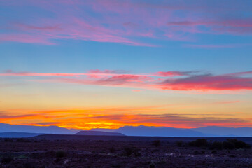 Pink and yellow colored clouds after sunset in the Karoo