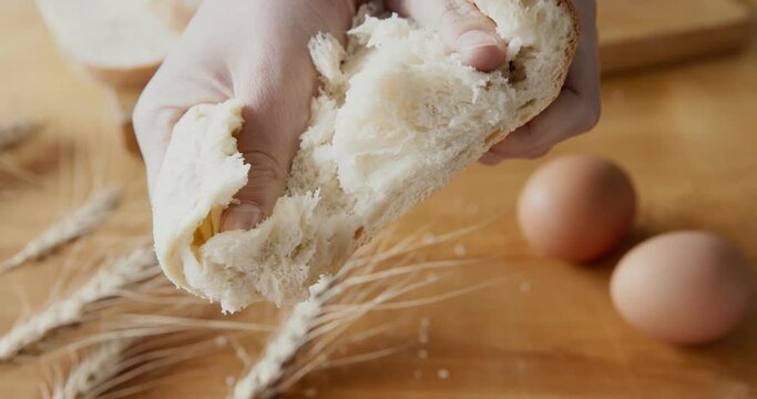 Woman breaking in half fresh baked bread