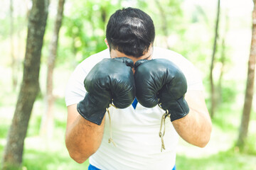 Man athlete concentrated face with sport gloves practicing boxing nature background. Boxer ready to fight. Sportsman boxer training with boxing gloves.