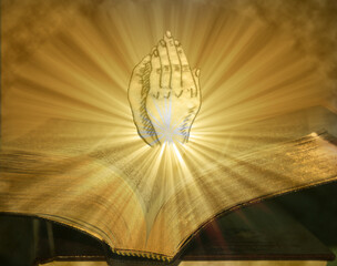 Praying Hands Coming From Open Bible