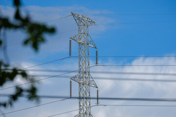 high voltage post.High-voltage tower sky background,With leaves in the foreground