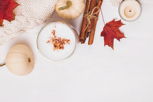 Warming cup of coffee, cinnamon, autumn leaves and pumpkins