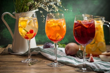 Delicious summer lemonades with ice, strawberry, peach and lime Three glasses with of cocktail on wooden table
