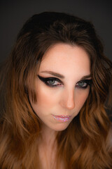 Fototapeta premium Modelo de maquillaje pelirroja en fondo oscuro