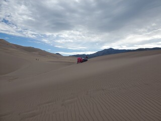 Fototapeta na wymiar Man on a sand dune from a distance
