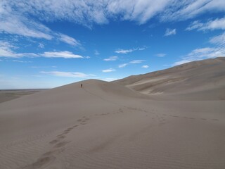 Obraz na płótnie Canvas Man on a sand dune from a distance