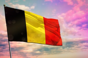 Fluttering Belgium flag on colorful cloudy sky background. Prosperity concept.