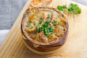 French Onion Soup. Classic traditional french restaurant bistro menu item. French onion soup, yellow onions reduced in broth topped with cheese melted and served with homemade baguettes. 