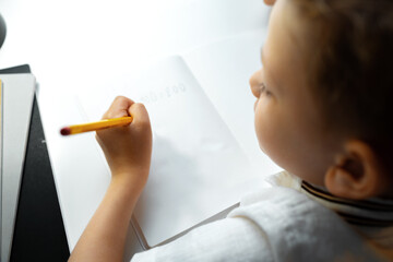 Little boy writing something in his notebook