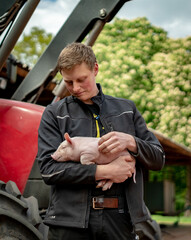Ferkelerzeugung - Strukturwandel,  besorgt blickender Landwirt mit einem Ferkel im Arm. © Countrypixel