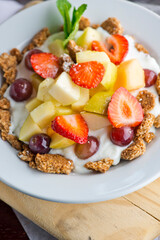 Yogurt parfait with granola. Classic breakfast or brunch favorite. Fresh fruits, pineapple, strawberries, cantaloupe, honeydew melon, grapes and raspberries served with Greek yogurt and granola.