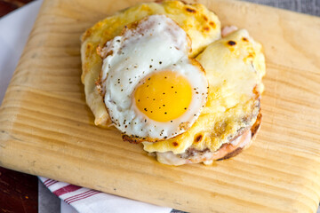 Sunny side up eggs with country potato hash served in a cast iron skillet. muffin with country ham, melted cheese, fried egg & homemade hollandaise sauce. Classic French or American cuisine favorite.