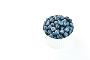Juicy and ripe Blueberries in a white plate on a white background
