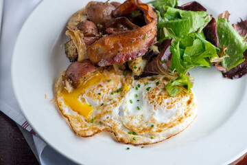 Omelette made with bacon, ham, sausage, bell peppers, heirloom tomatoes, spinach, onions, cheddar & Swiss cheese. Served with crispy potato hash, a classic American breakfast or brunch favorite.