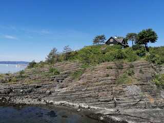 Fototapeta na wymiar cottage on a hill on an island in the ocean