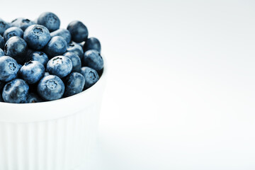 Blueberries in a white Cup on a white background. Isolate, free space