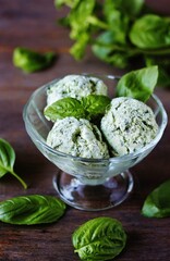 Homemade basil ice cream with fresh basil on a dark background. Copy space