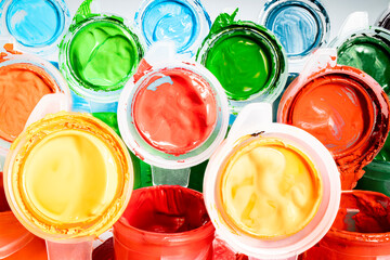 Multi-colored gouache paints and brushes. Materials for drawing and creativity. Bright water-based paints. School supplies. Hobbies and creativity