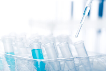 microbiological pipette in the genetic laboratory. study of a virus or vaccination. blue tinted.