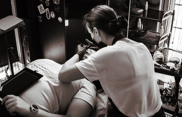 Girl artist paints an eyebrow tattoo. The process of tattooing. Permanent makeup