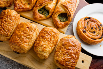 Croissants and assortment of breakfast pastries. Chocolate croissants, cinnamon rolls, and puff pastries filled with spinach and Asiago cheese served in a classic French Bistro. 