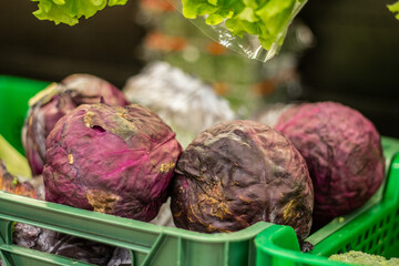 Purple cabbages in plastic green box in the store.