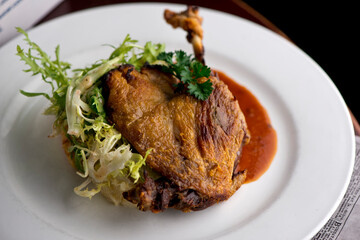Duck. Prepared in classic French bistro style. Duck rendered in fat until skin is a crispy golden brown. Served with a frisee salad. 