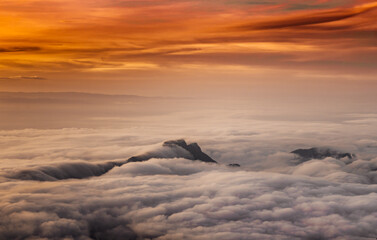 The mist over the mountain and sunrise twiligt sky in orange tone.