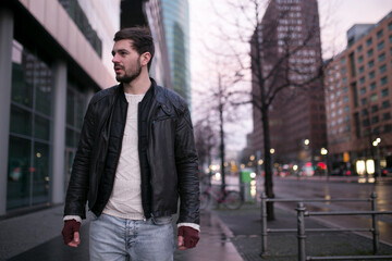 Profile portrait of a sad lone man in a jacket and a hood in the rain. Bad stormy rainy weather sorrow concept.