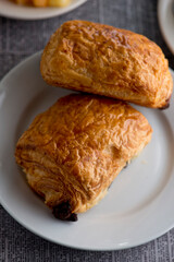 Croissants and assortment of breakfast pastries. Chocolate croissants, cinnamon rolls, and puff pastries filled with spinach and Asiago cheese served in a classic French Bistro. 
