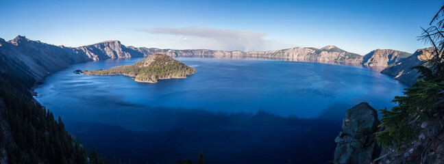 Panorama view of Crater Lake in Oregon, with blue sky.