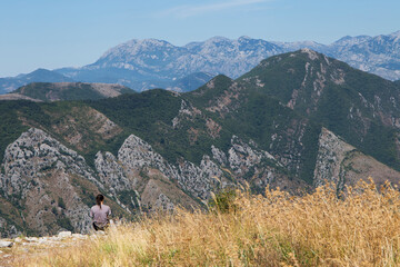 Girl looking at the mountains. View of the mountains from the top.
