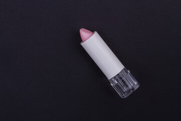 Matte pink lipstick without a cap on blackbackground. Perfect glamorous photo.