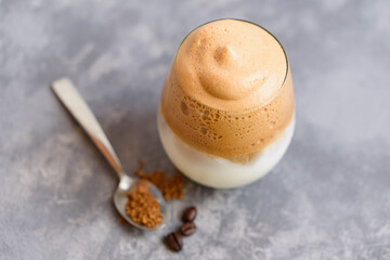 Iced Dalgona Coffee trendy fluffy creamy whipped latte espresso with foam in transparent glass on marble background. Trendy drink city lock down and self quarantine, stay at home concept.
