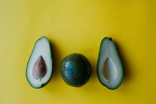 Fresh lettuce, avocado in a small pot. Green leaves on a yellow background. Flat lay. Eco food. Place for text