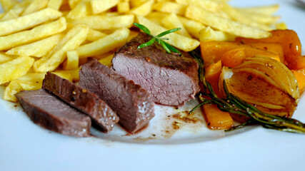 ready to eat - roasted venison from the chamois buck with vegetables and french fries on a white plate