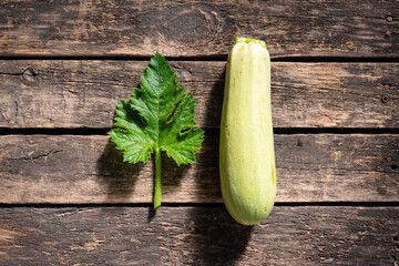 Zucchini fruit on wooden garden table background.