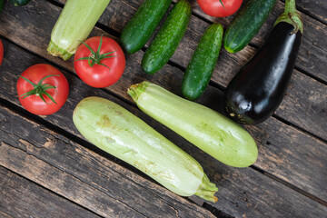 Various vegetables on the wooden garden table background.