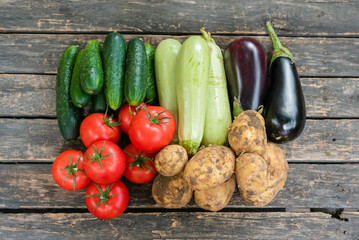 Various vegetables on the wooden garden table background.