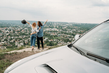 Young Trendy Traveling Couple Having Fun Near the Car on Top of Hill, Travel and Road Trip Concept