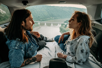 View Through Car Trunk Young Trendy Traveling Hipsters Having Fun and Enjoying Road Trip, Travel Concept