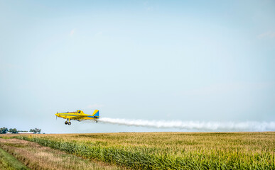 Crop duster sprays pesticide on an agricultural field to deter insects from destroying crops.