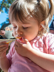 Little girl eating snacks outdoors