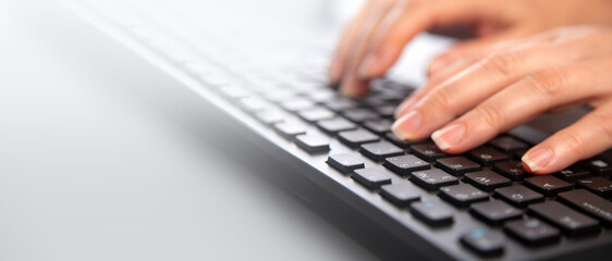 Detail of female fingers typing on keyboard. - obrazy, fototapety, plakaty