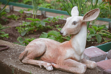 Figure decorative roe deer. A vegetable garden and beds in a country house.